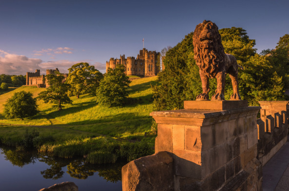 Alnwick Castle at sunset, the keep and curtain wall against a late Northumberland sky