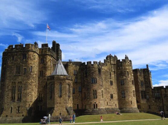 Visitors walking the outer bailey at Alnwick Castle